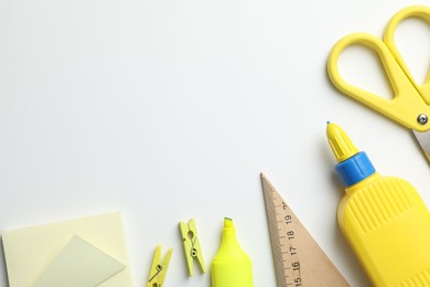 Photo of Glue and other stationery on white background, flat lay. Space for text