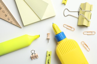 Photo of Glue and other stationery on white background, flat lay