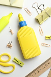 Photo of Glue and other stationery on white background, flat lay