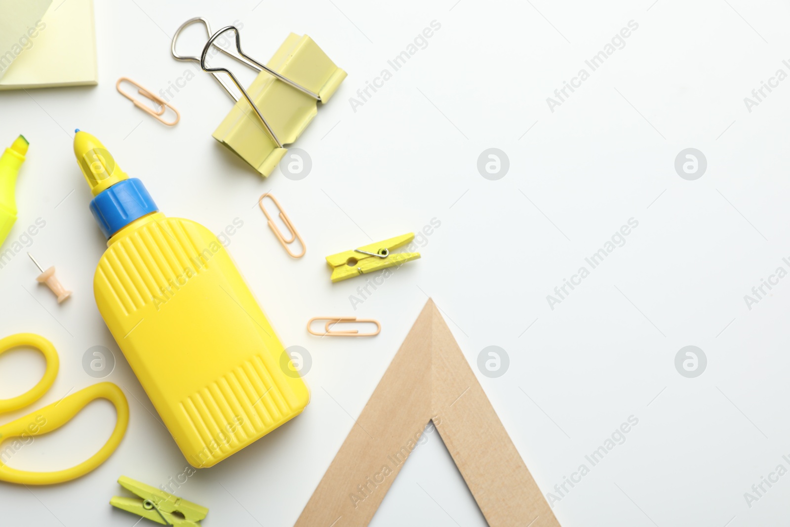 Photo of Glue and other stationery on white background, flat lay. Space for text