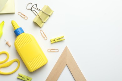 Photo of Glue and other stationery on white background, flat lay. Space for text
