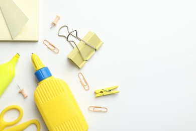 Photo of Glue and other stationery on white background, flat lay. Space for text