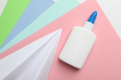 Photo of Glue and color paper on white background, flat lay