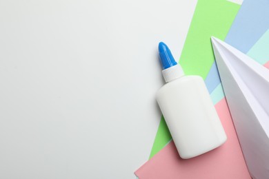 Photo of Glue and color paper on white background, flat lay. Space for text