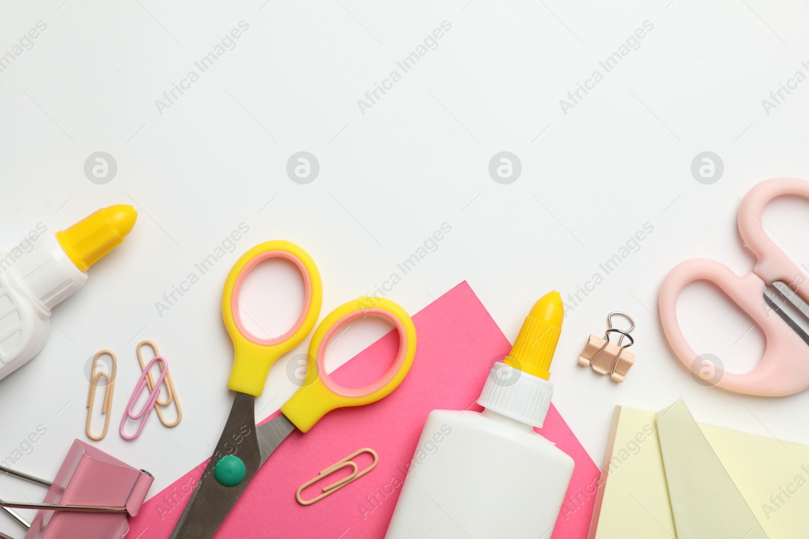 Photo of Glue and other stationery on white background, flat lay. Space for text