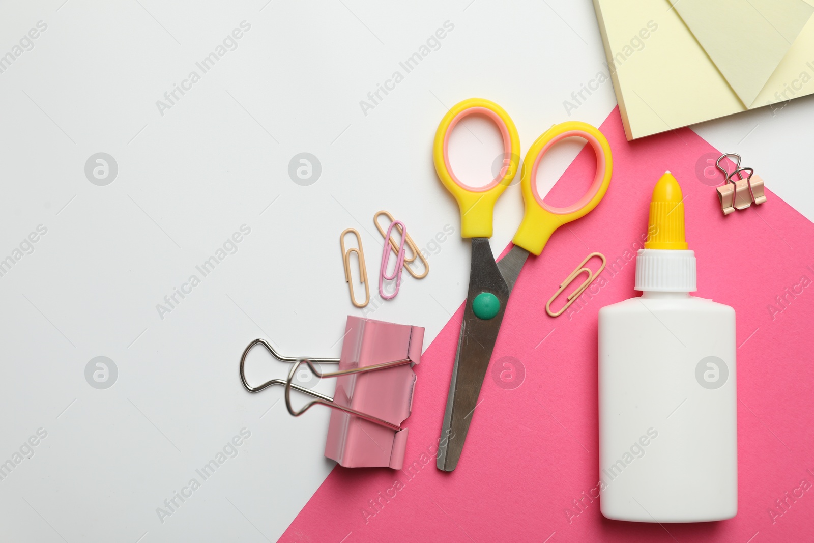 Photo of Glue and other stationery on white background, flat lay. Space for text
