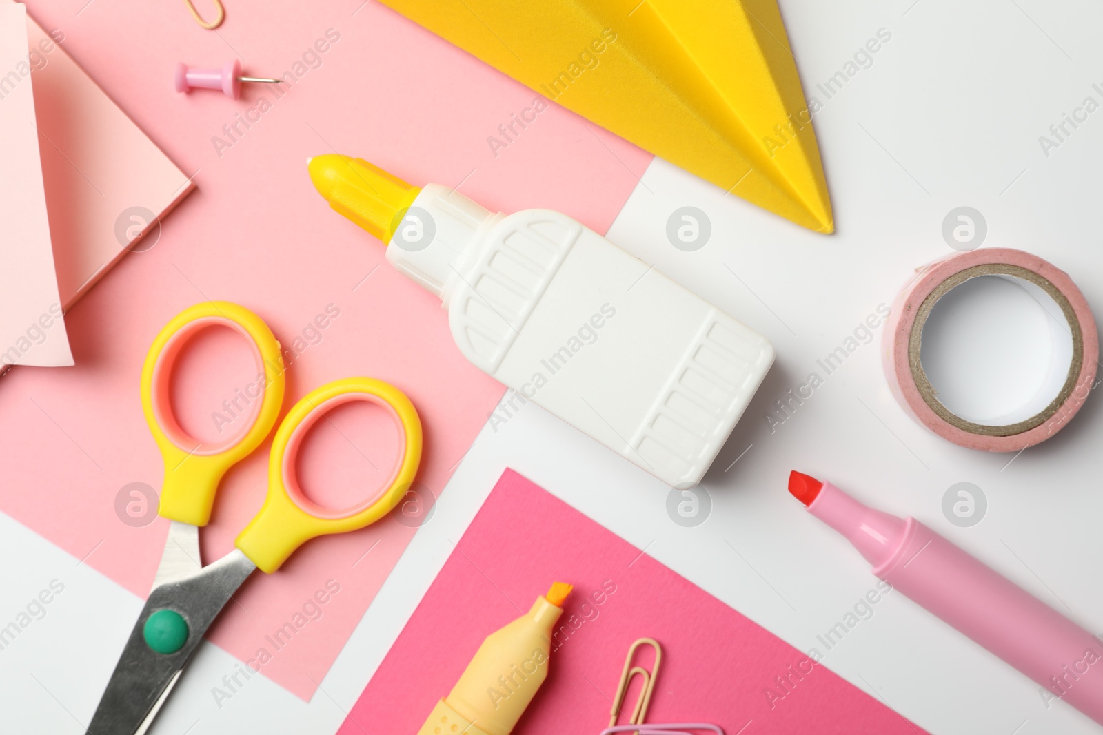 Photo of Glue and other stationery on white background, flat lay