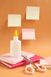 Photo of Glue and other stationery on pale orange background