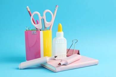 Photo of Glue and other stationery on light blue background