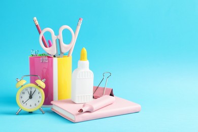 Photo of Glue and other stationery on light blue background. Space for text
