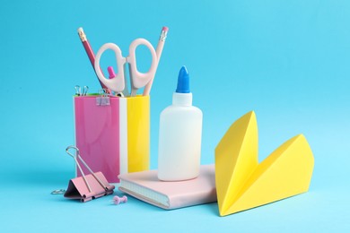 Photo of Glue and other stationery on light blue background