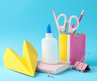 Photo of Glue and other stationery on light blue background