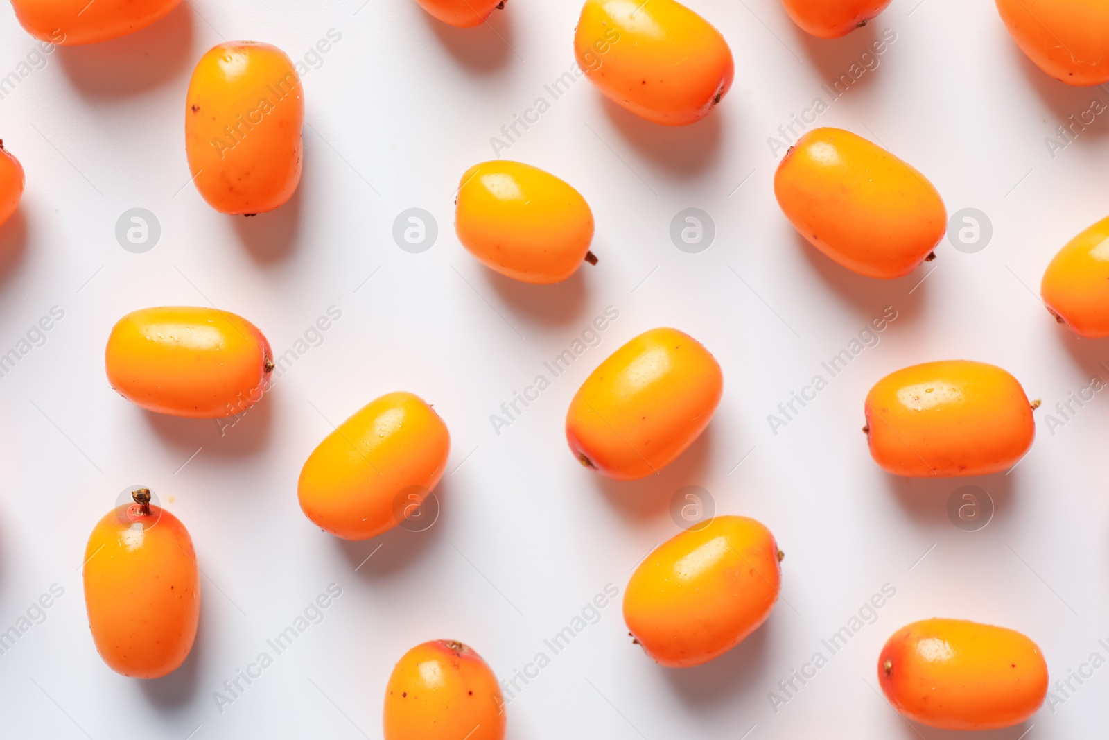 Ripe sea buckthorn berries and leaves on white background, flat lay Photo of Ripe sea buckthorn berries and leaves on white background, flat lay