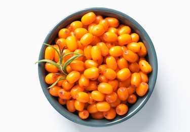 Photo of Ripe sea buckthorn berries and leaves in bowl on white background, top view