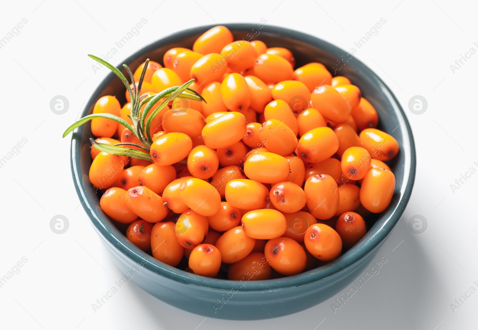 Photo of Ripe sea buckthorn berries and leaves in bowl on white background, closeup