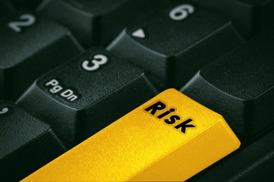 Image of Yellow button with word Risk on computer keyboard, closeup