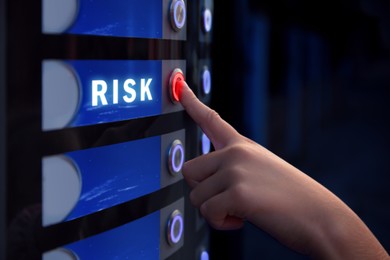 Image of Woman pressing button near word Risk on vending machine, closeup
