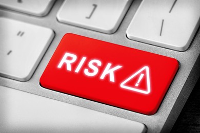 Image of Red button with word Risk and warning sign on computer keyboard, closeup