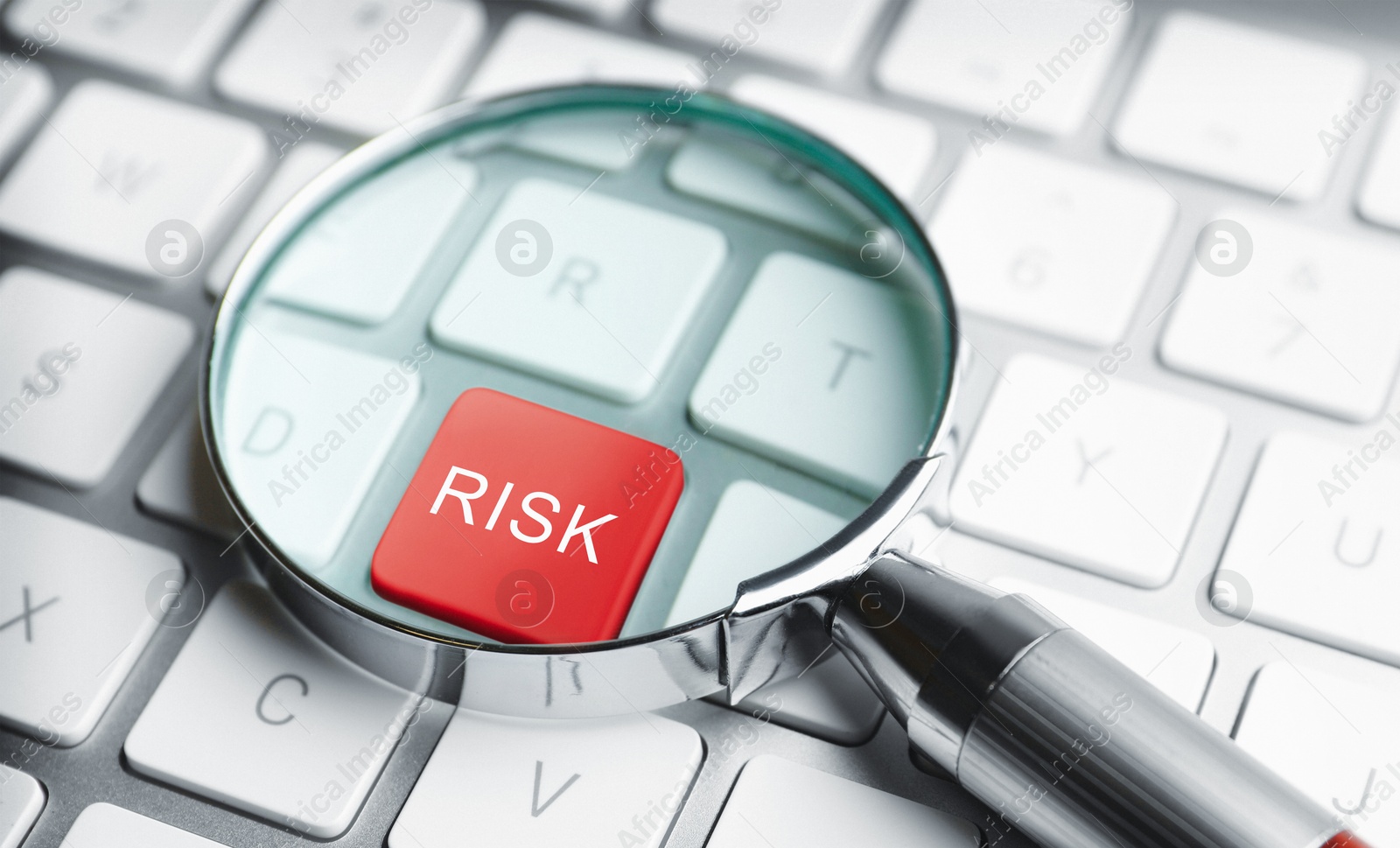 Magnifying glass on red button with word Risk on computer keyboard, closeup Image of Magnifying glass on red button with word Risk on computer keyboard, closeup