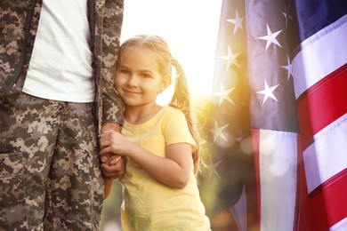 Image of Military man and his daughter outdoors, double exposure with national flag of USA