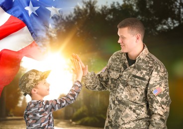 Image of Military man giving his son high five outdoors, double exposure with national flag of USA