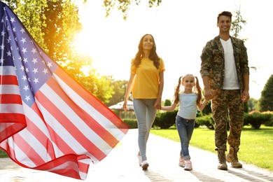 Image of Military man walking with his family outdoors, double exposure with national flag of USA