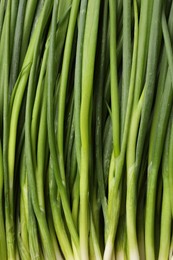 Photo of Fresh green spring onions as background, top view