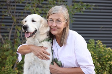 Photo of Portrait of senior woman with adorable Golden Retriever dog outdoors