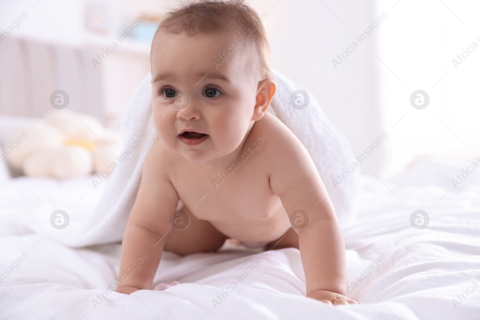Photo of Cute baby with white towel after bathing on bed at home