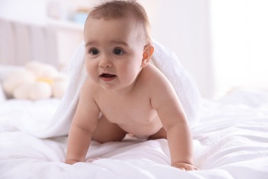 Photo of Cute baby with white towel after bathing on bed at home