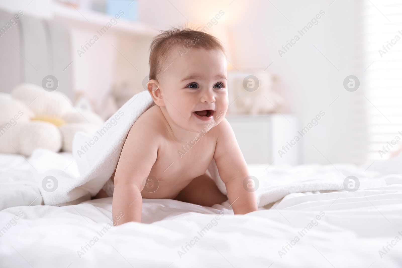 Photo of Cute baby with white towel after bathing on bed at home, space for text