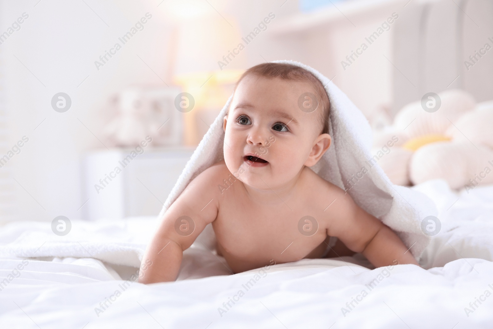 Photo of Cute baby with white towel after bathing on bed at home