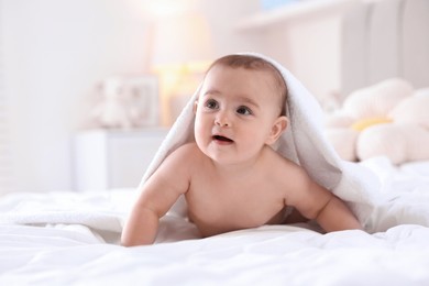 Photo of Cute baby with white towel after bathing on bed at home