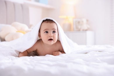 Photo of Cute baby with white towel after bathing on bed at home, space for text