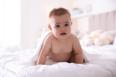 Photo of Cute baby wrapped with white towel after bathing on bed at home