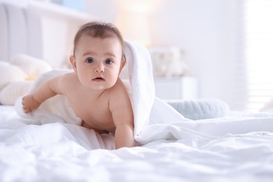 Photo of Cute baby wrapped with white towel after bathing on bed at home, space for text