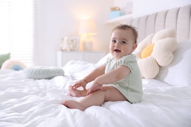 Photo of Cute little baby on bed at home, space for text