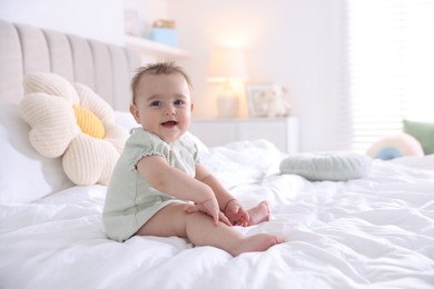 Photo of Cute little baby on bed at home, space for text