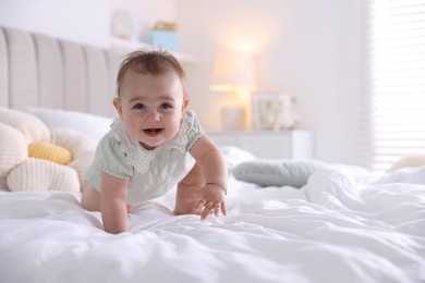 Photo of Cute little baby on bed at home, space for text