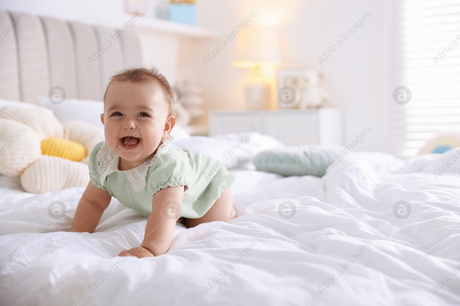 Cute little baby on bed at home, space for text Photo of Cute little baby on bed at home, space for text