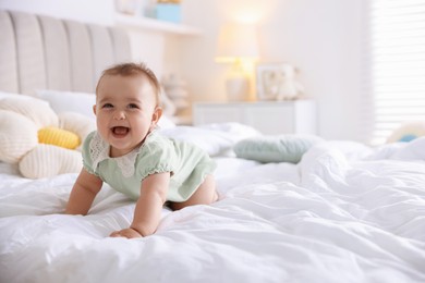 Photo of Cute little baby on bed at home, space for text