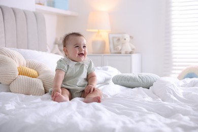 Photo of Cute little baby on bed at home, space for text