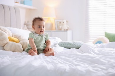 Photo of Cute little baby on bed at home, space for text