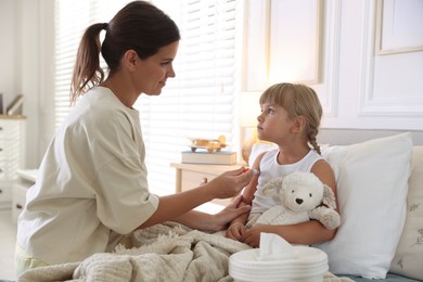 Photo of Mother and her sick daughter in bed at home