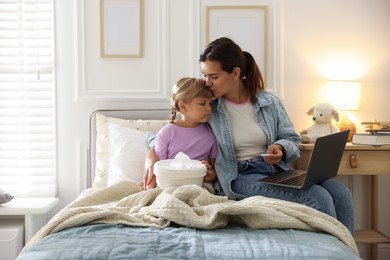 Photo of Telehealth. Mother and her sick daughter having online consultation with doctor via laptop on bed at home