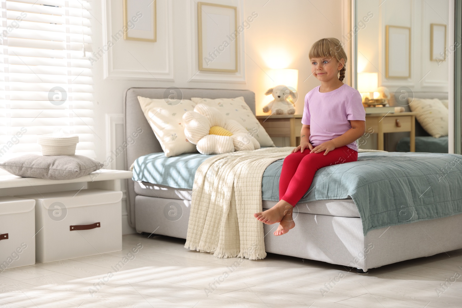 Photo of Cute little girl on bed at home. Space for text