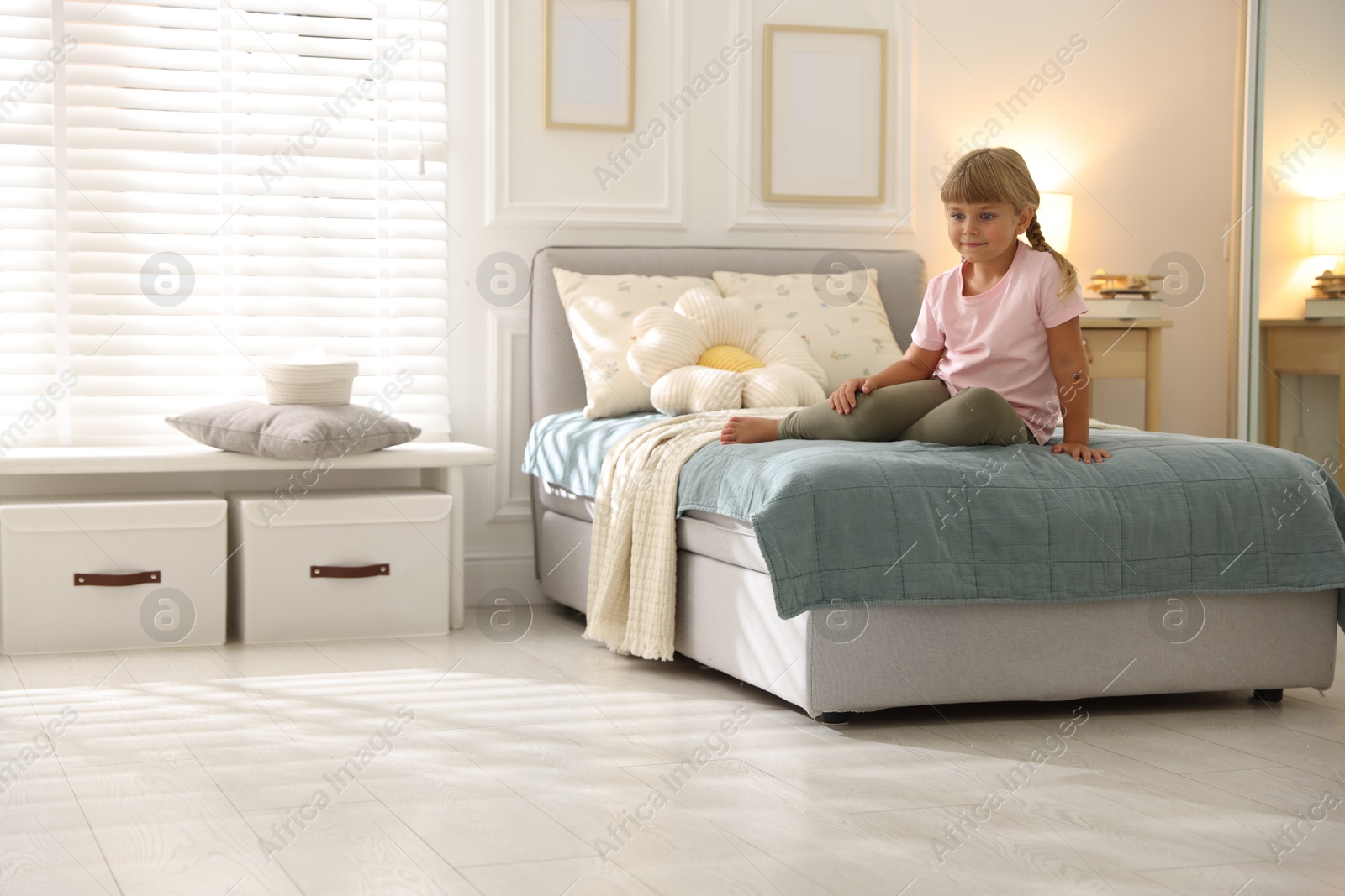 Cute little girl on bed at home. Space for text Photo of Cute little girl on bed at home. Space for text