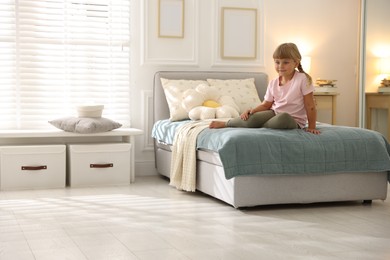 Photo of Cute little girl on bed at home. Space for text