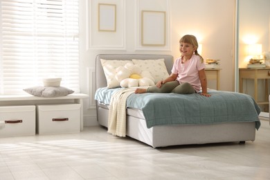 Photo of Cute little girl on bed at home. Space for text