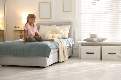Photo of Cute little girl on bed at home. Space for text